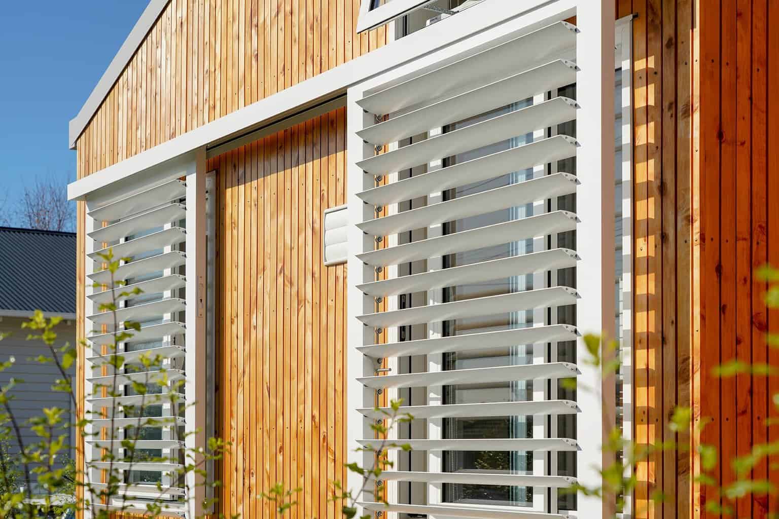 Exterior sliding louvres used for passive solar control and privacy on a modern residential home