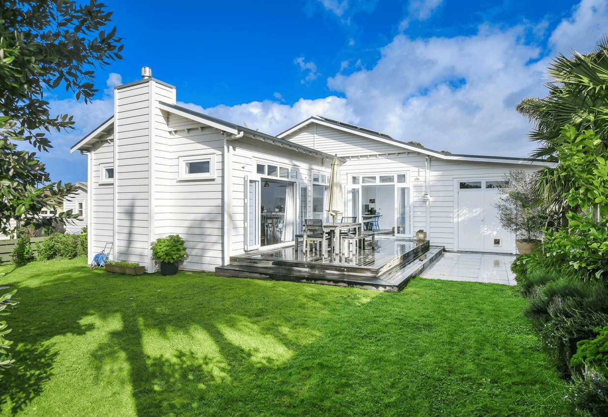 Large timber bi-folding doors connecting the modernized villa interior to a generous outdoor entertaining deck for perfect indoor-outdoor flow